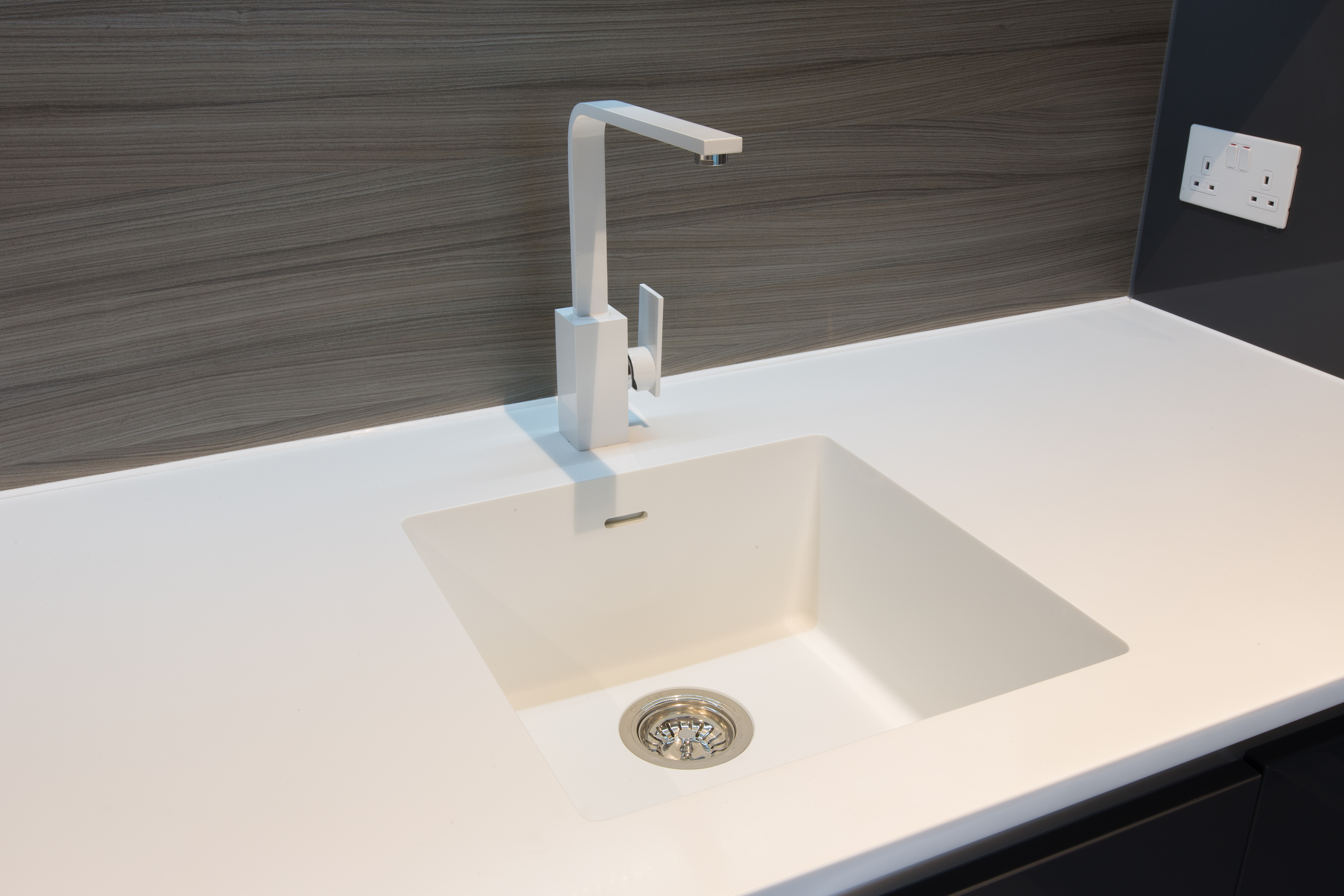 A white Corian countertop with a matching sink 